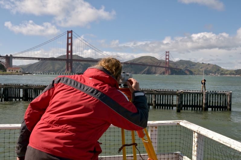 Members of CO-OPS’ Field Operations Division perform routine surveying to monitor water level sensor stability in San Francisco, CA.